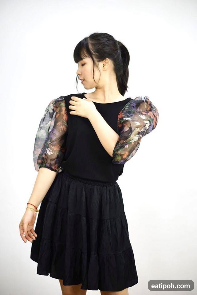 Woman in black dress with floral sleeves