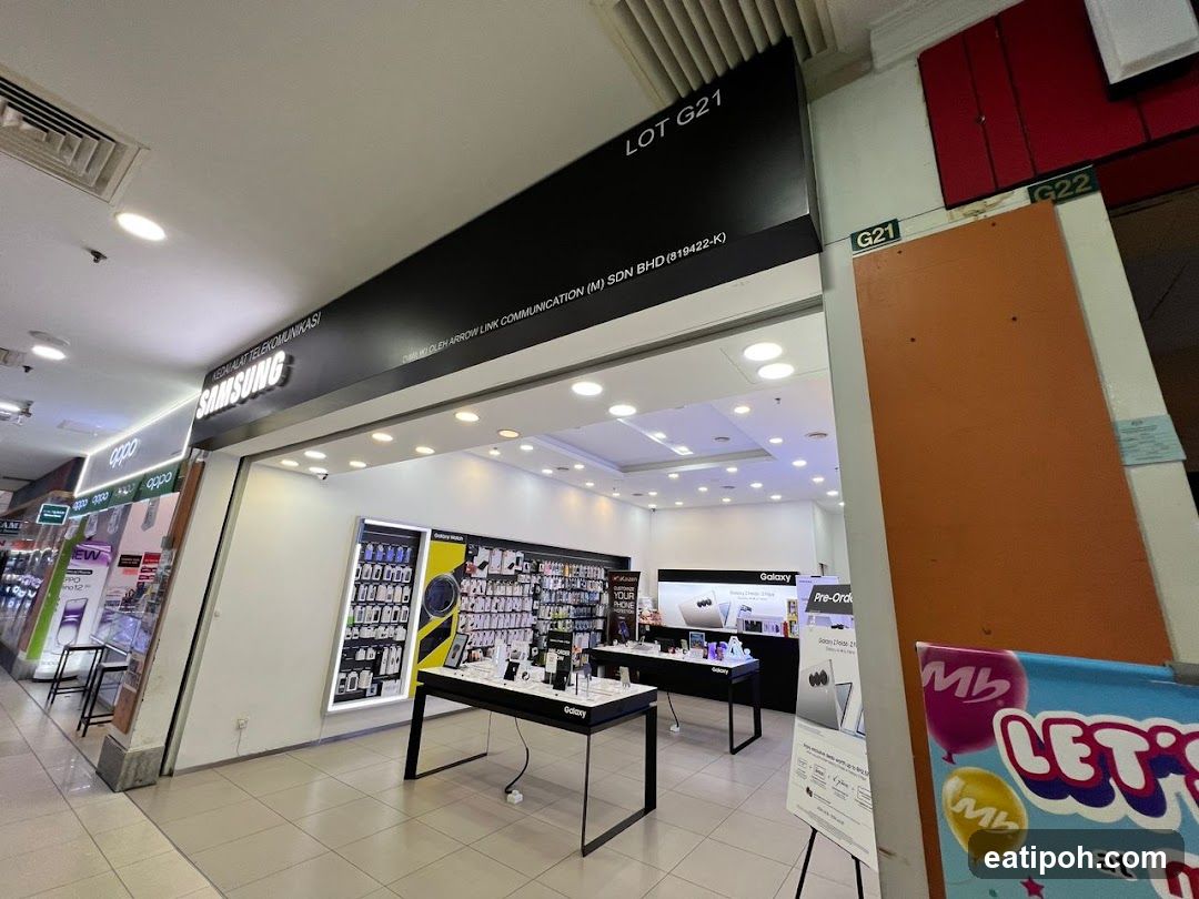 The exterior of a Samsung electronics store in a mall. The store has a prominent Samsung logo and displays various mobile phones and accessories. Adjacent to the Samsung store is an Oppo store.