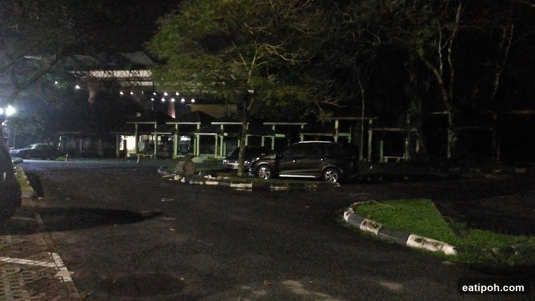 Nighttime view of a building complex with cars parked outside