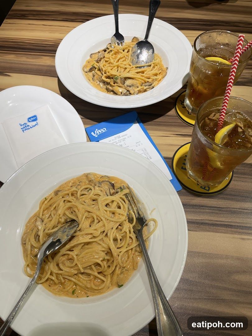 Two plates of pasta with drinks