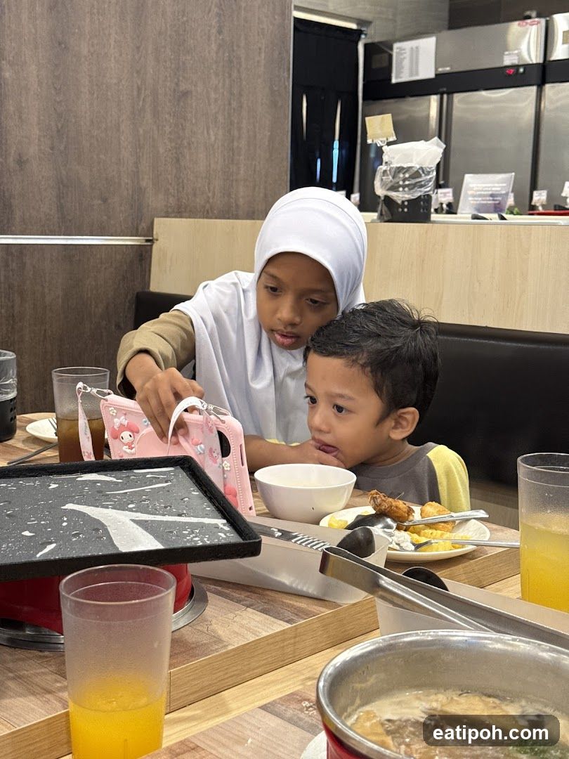 Children watching a video on a phone at a restaurant